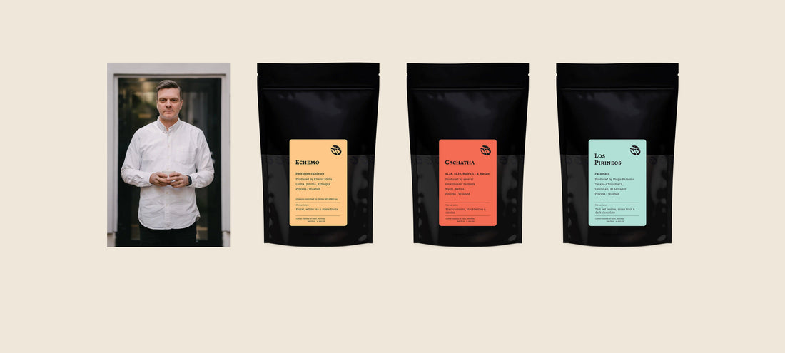 Four black Tim Wendelboe coffee bags with yellow, orange and teal labels, beside a portrait of a man in a white shirt.